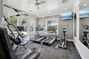 a home gym with exercise equipment and windows